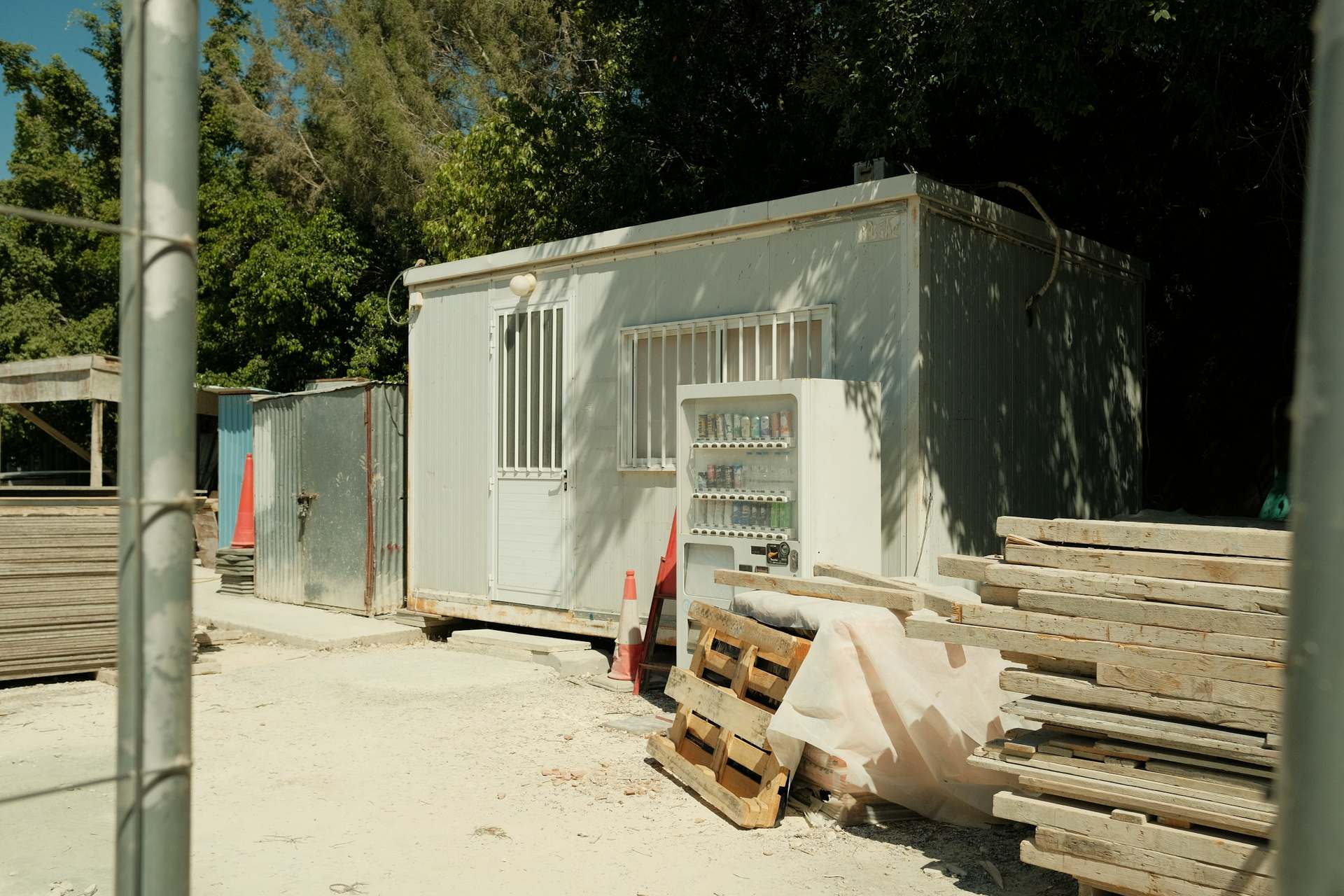 Bâtiment modulaire blanc posé sur un site, avec des matériaux de construction à côté.